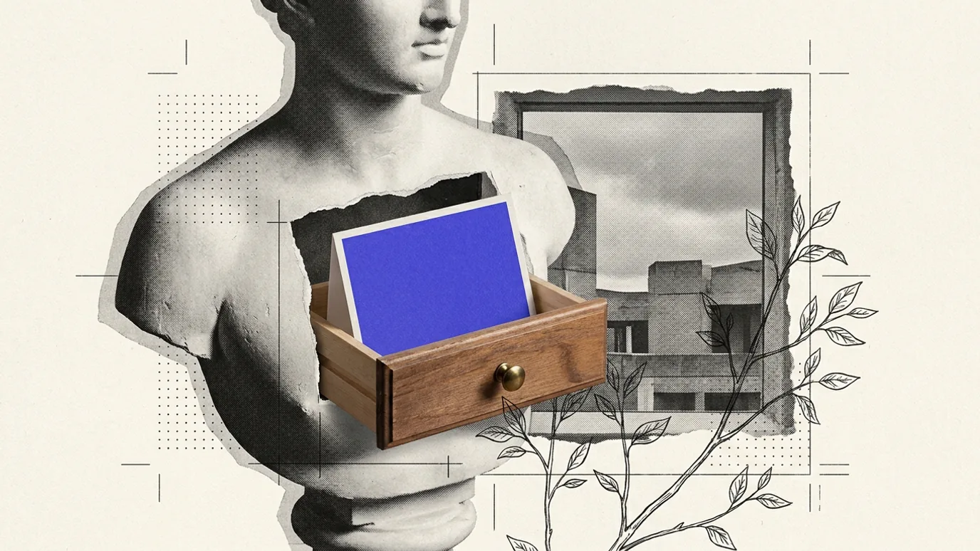 A plaster bust with a wooden drawer open in its chest holding a blue-violet card, in front of a framed view of a concrete building.