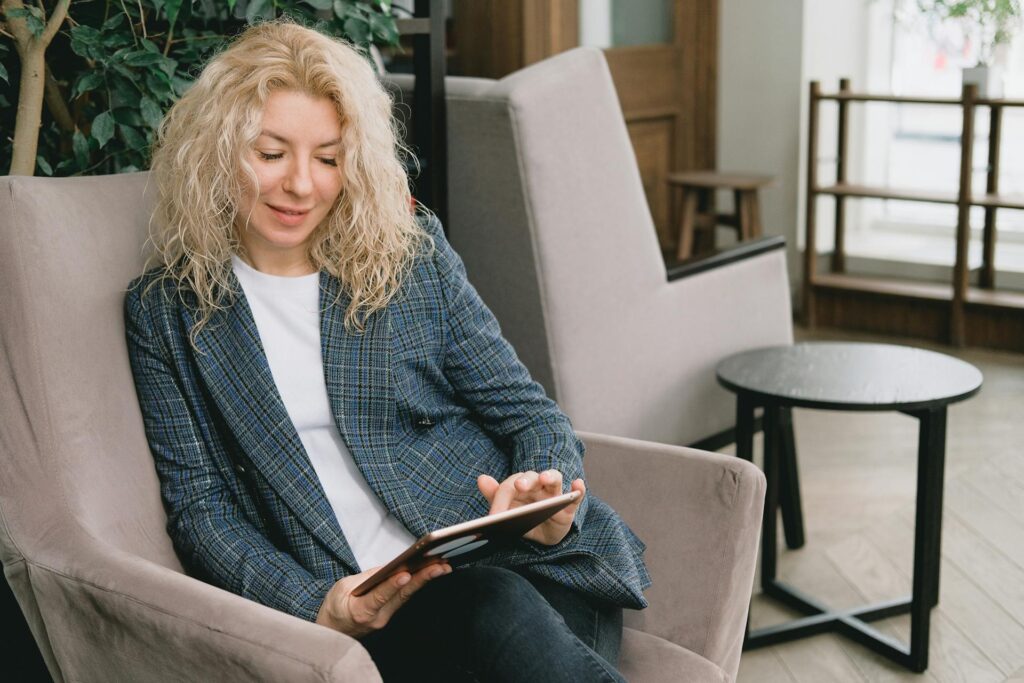 Sephora’s Virtual Artist: AI and AR’s Impact on E-commerce Conversion A woman seated indoors using a tablet, enjoying leisure time - sephora virtual artist